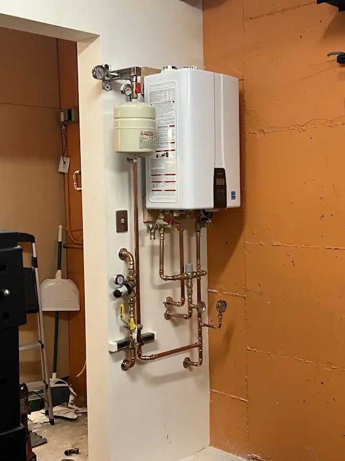 Plumbing technician inspecting water heater connections in Sitka